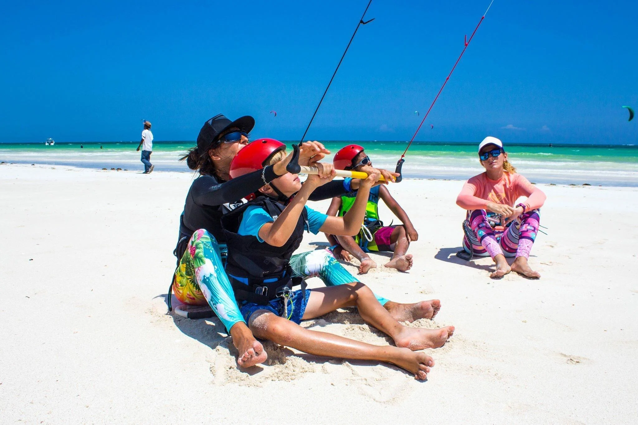Kitesurfing students wearing safety equipment during a professional lesson at Diani Beach